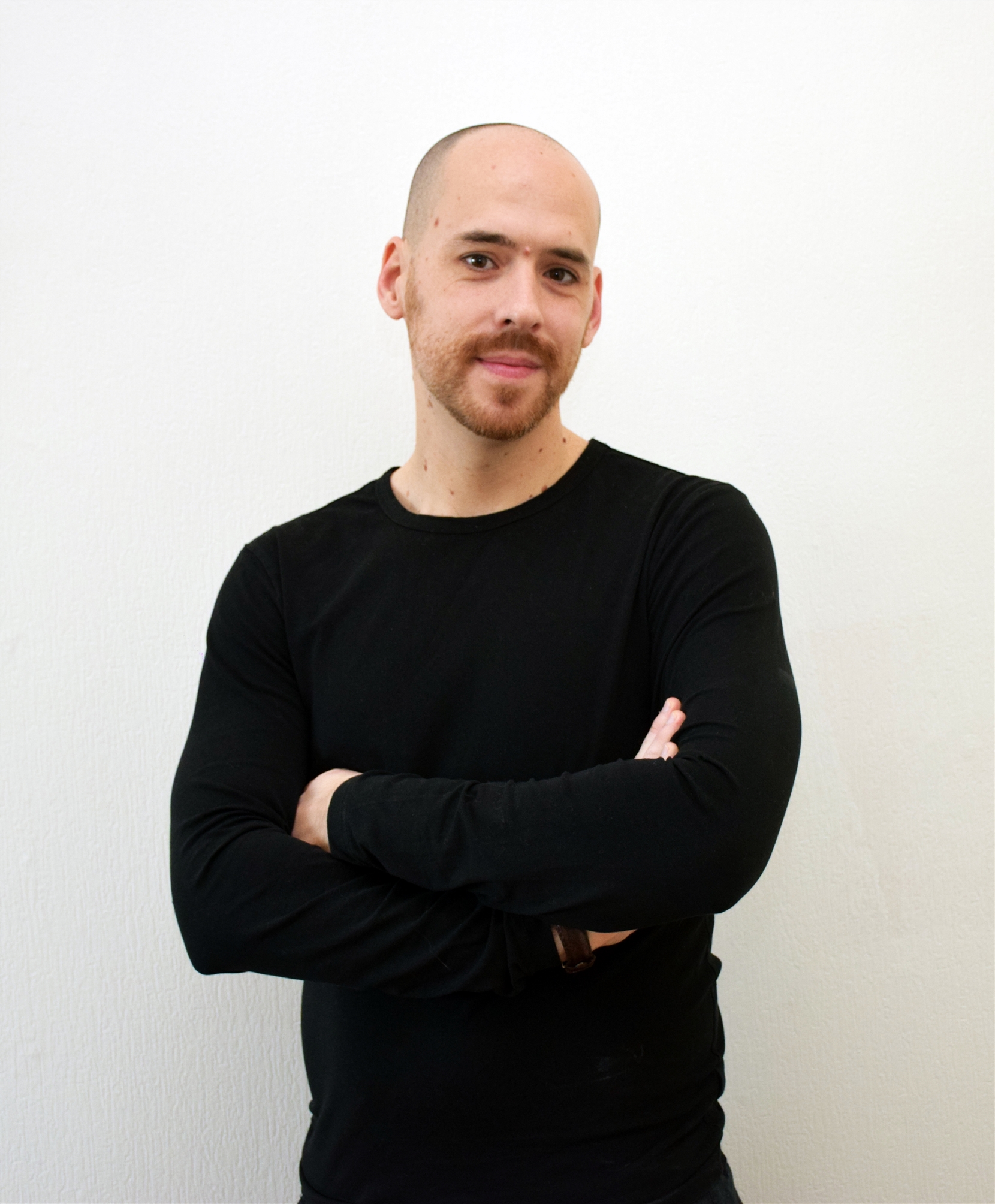 Man in black long sleeve shirt smiles at camera