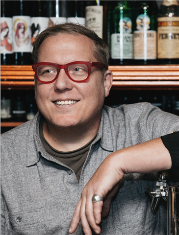 Headshot of man in red rimmed glasses