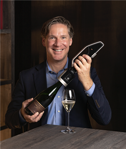 Man in blue suit with Coravin preservation system